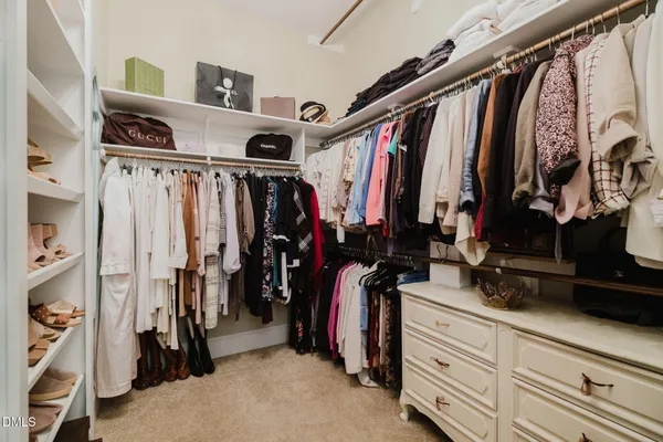 a spacious bedroom with a bed and a chandelier