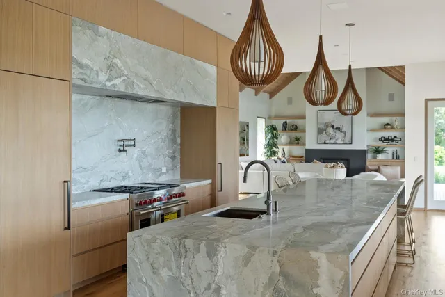 a kitchen with stainless steel appliances granite countertop a sink a stove and a wooden floors