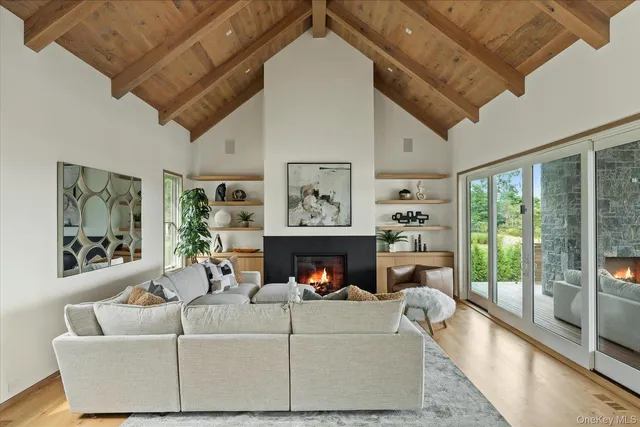 a living room with furniture a fireplace and a floor to ceiling window