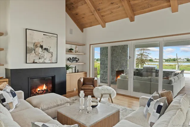a living room with furniture a large window and a fireplace