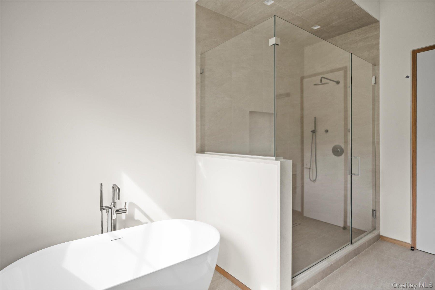 551 Main Street Quiogue, NY 11978 - Photo 31 of 50 Bathroom with a shower stall, a freestanding bath, and light tile patterned floors