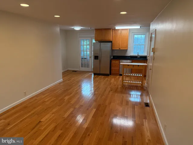 a view of empty room with wooden floor