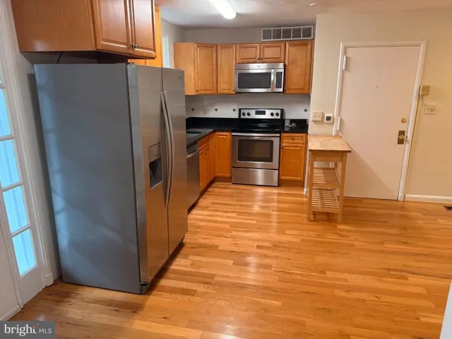 a view of kitchen with cabinets and wooden floor