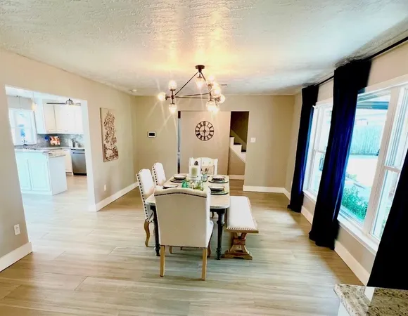 a kitchen with granite countertop kitchen island stainless steel appliances a stove a sink a refrigerator a center island cabinets and wooden floor