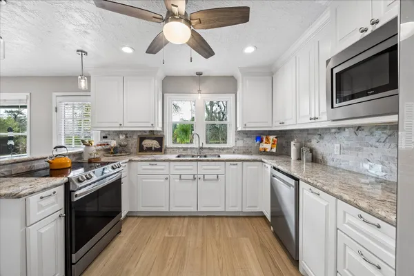 a view of a kitchen with wooden floor and a window