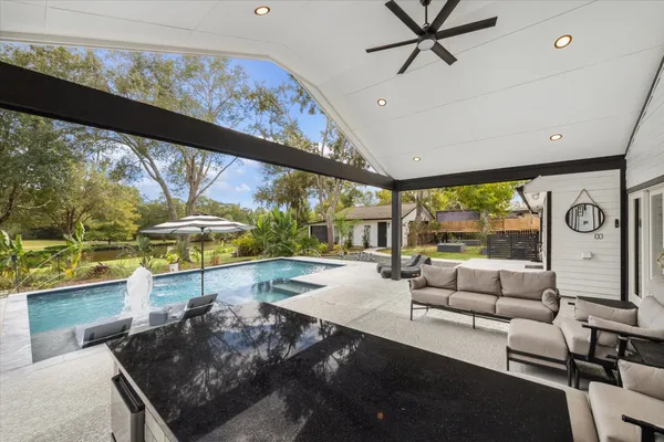 a view of swimming pool with outdoor seating and plants