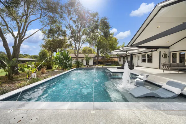 a front view of a house with swimming pool yard and outdoor seating