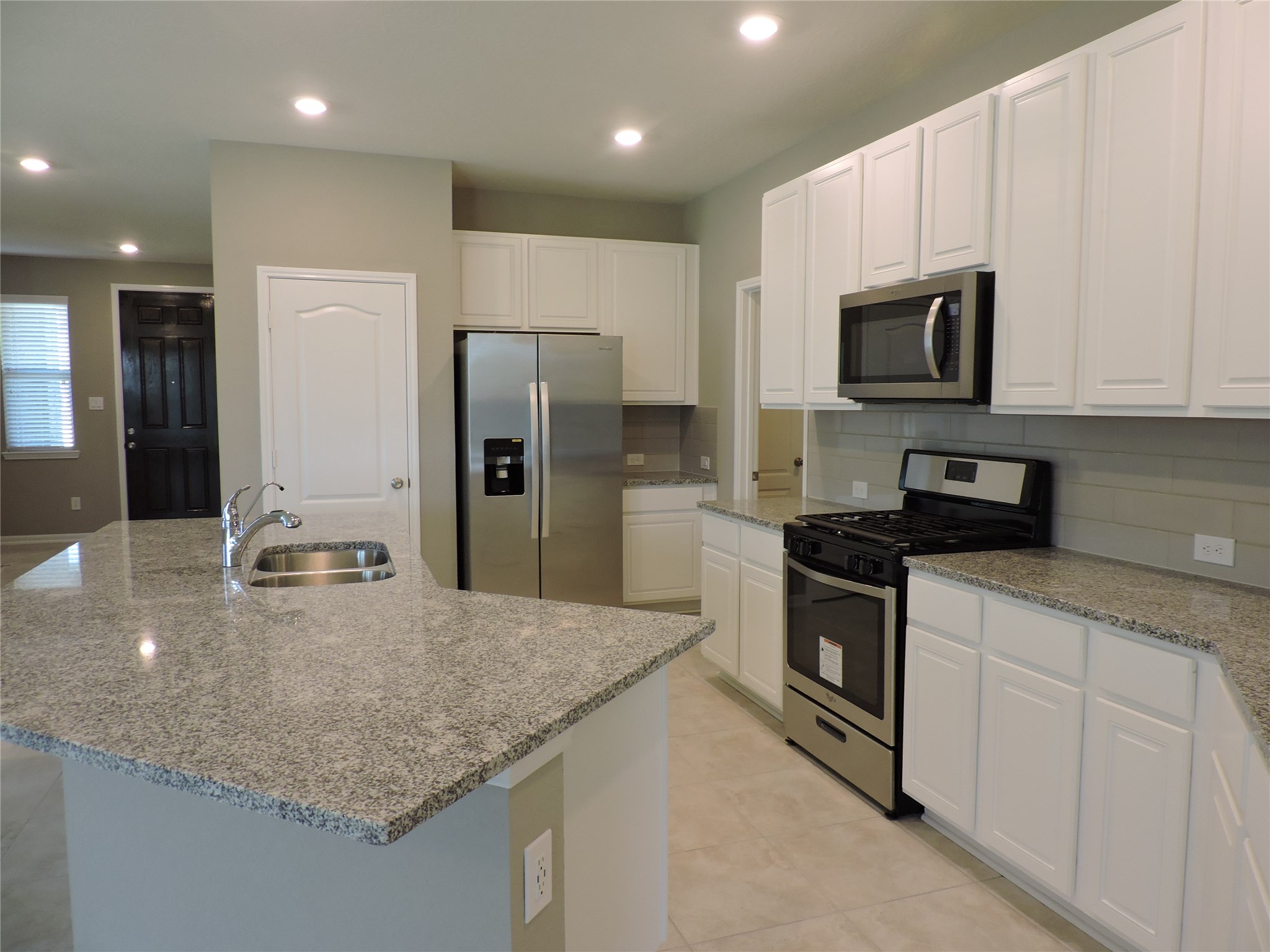 1102 Upton Court Conroe, TX 77304 - Photo 8 of 30 a kitchen with stainless steel appliances granite countertop a sink a stove and a refrigerator