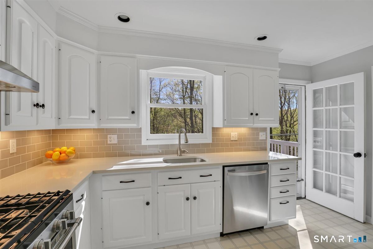 9 Academy Road Trumbull, CT 06611 - Photo 7 of 35 a kitchen with white cabinets and appliances