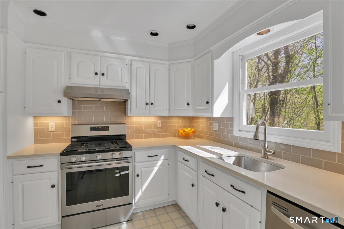 9 Academy Road Trumbull, CT 06611 - Photo 8 of 35 a kitchen with granite countertop a sink stainless steel appliances and cabinets