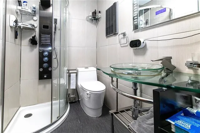 a bathroom with a sink a toilet and shower