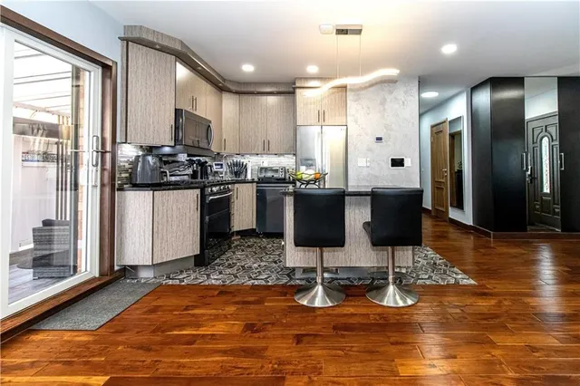 a kitchen with stainless steel appliances kitchen island granite countertop wooden cabinets and a granite counter tops