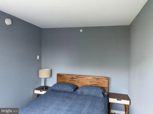a hallway with a computer on a table and a flat screen tv