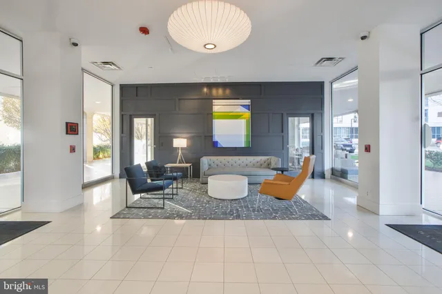 a living room with furniture a flat screen tv and a large window