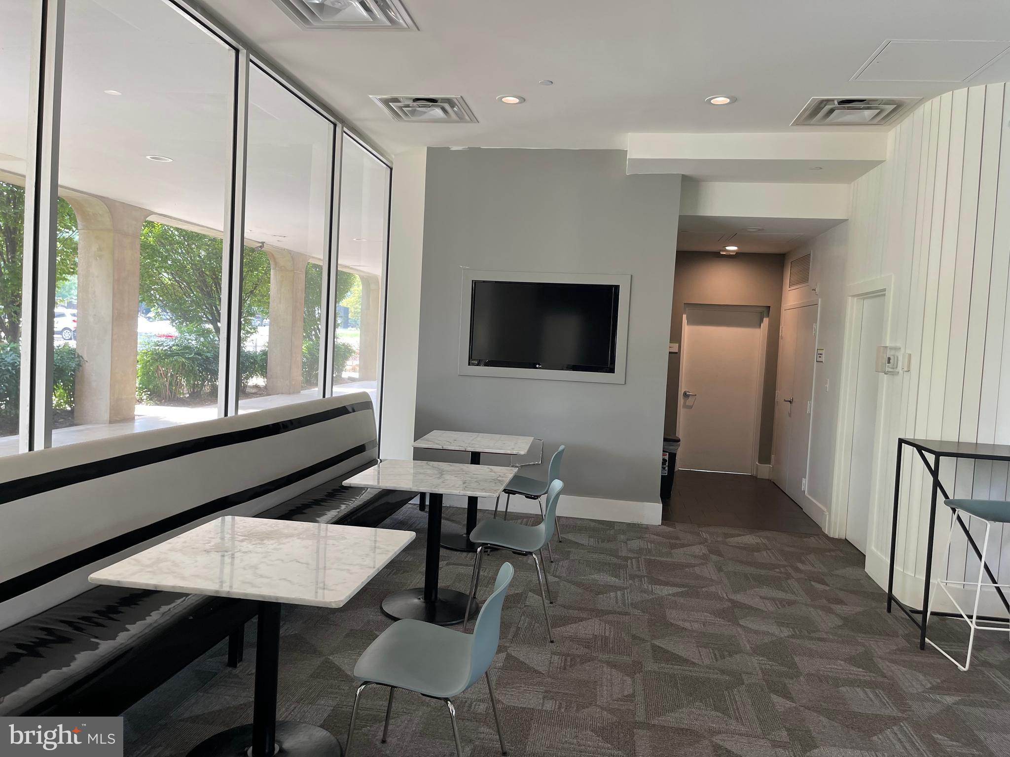 1101 3rd Street Southwest, Unit 403 Washington, DC 20024 - Photo 26 of 73 a living room with furniture a flat screen tv and a large window
