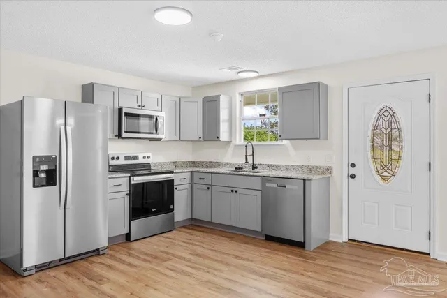 a kitchen with stainless steel appliances granite countertop a refrigerator sink and stove