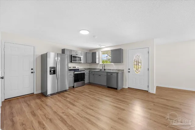a view of a kitchen with wooden floor and a refrigerator