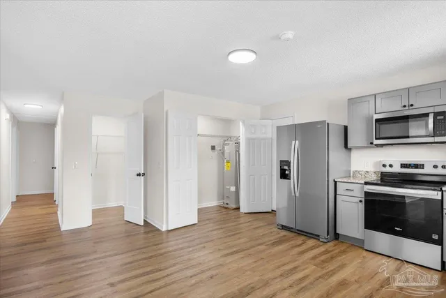 a metallic refrigerator freezer sitting in a kitchen