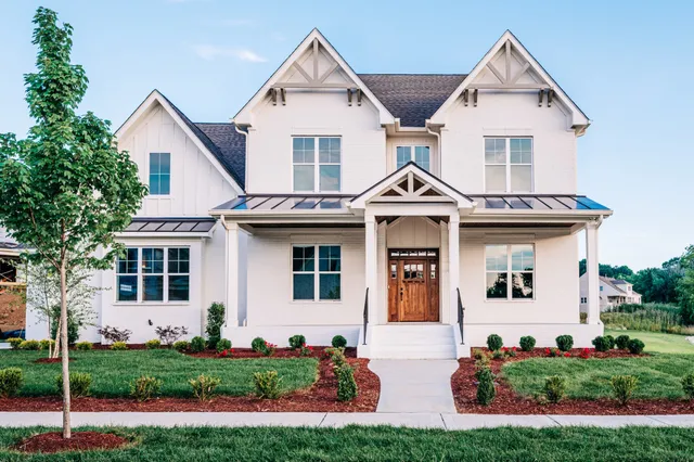 a front view of a house with a yard and trees