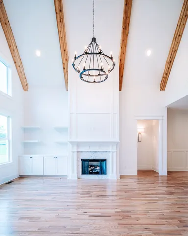 a view of a hallway with a fireplace and wooden floor