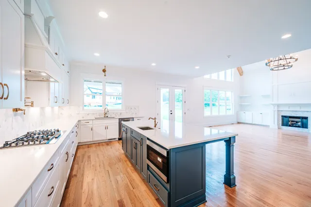 a kitchen with stainless steel appliances granite countertop a stove and a wooden floors