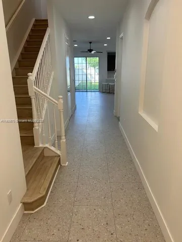 an entryway in a hall with wooden floor and a cabinet