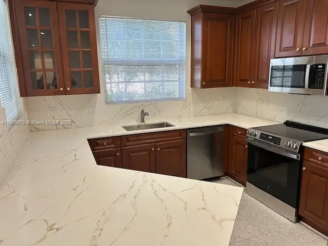 a kitchen with stainless steel appliances granite countertop a sink stove and cabinets