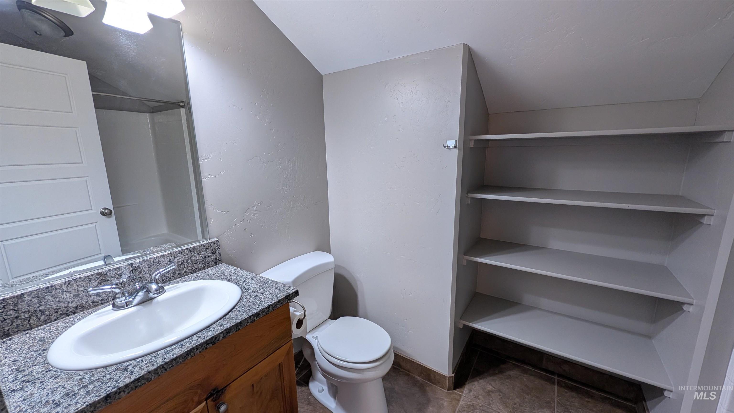 622 Lochsa Loop Heyburn, ID 83336 - Photo 12 of 17 Bathroom featuring a vanity with granite-style countertop and undermount sink, a white toilet, and built-in shelving