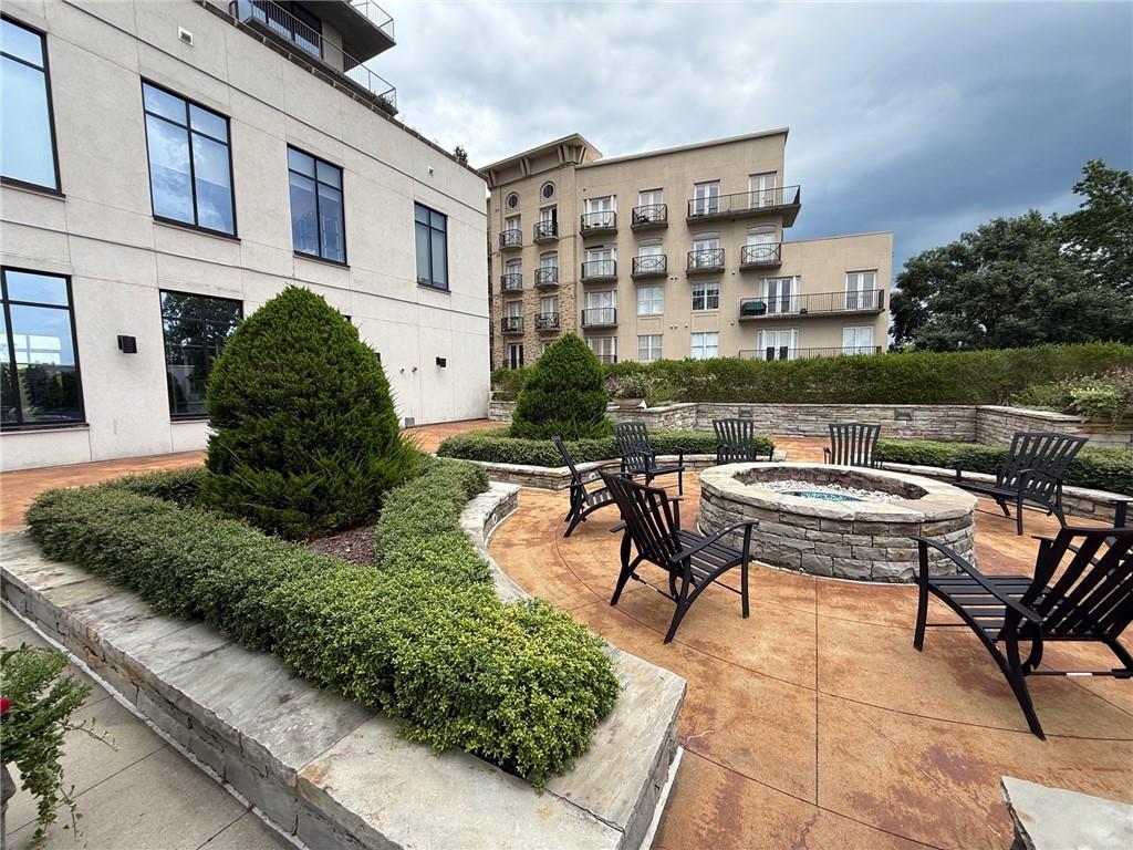2255 Peachtree Road Northeast, Unit 322 Atlanta, GA 30309 - Photo 22 of 25 a view of a patio with table and chairs potted plants and a large tree