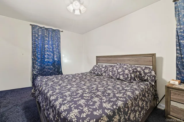 a large bed sitting in a bedroom next to a bed and a chandelier