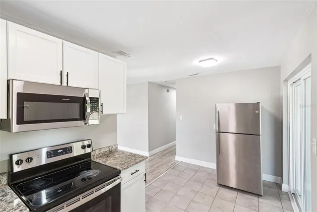 a kitchen with a refrigerator and a stove top oven