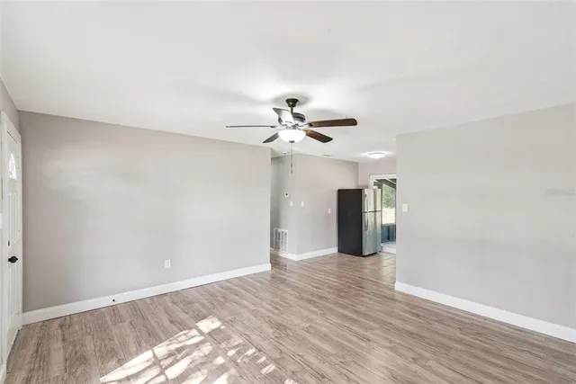 a view of a livingroom with wooden floor and a ceiling fan