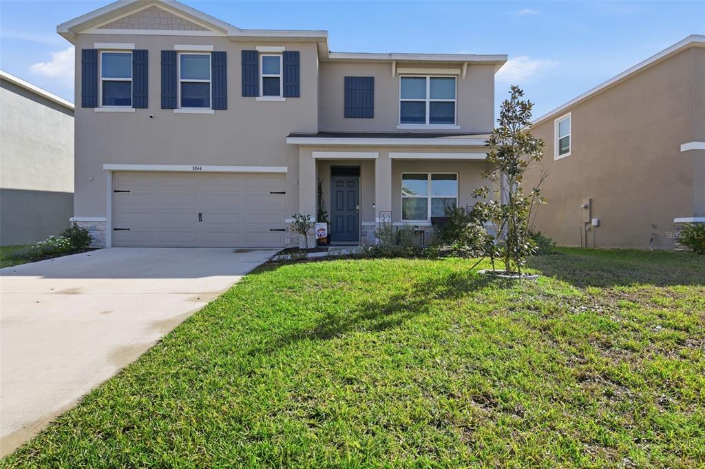3844 Sunny Spring Street Plant City, FL 33565 - Photo 13 of 26 a front view of a house with a yard and garage