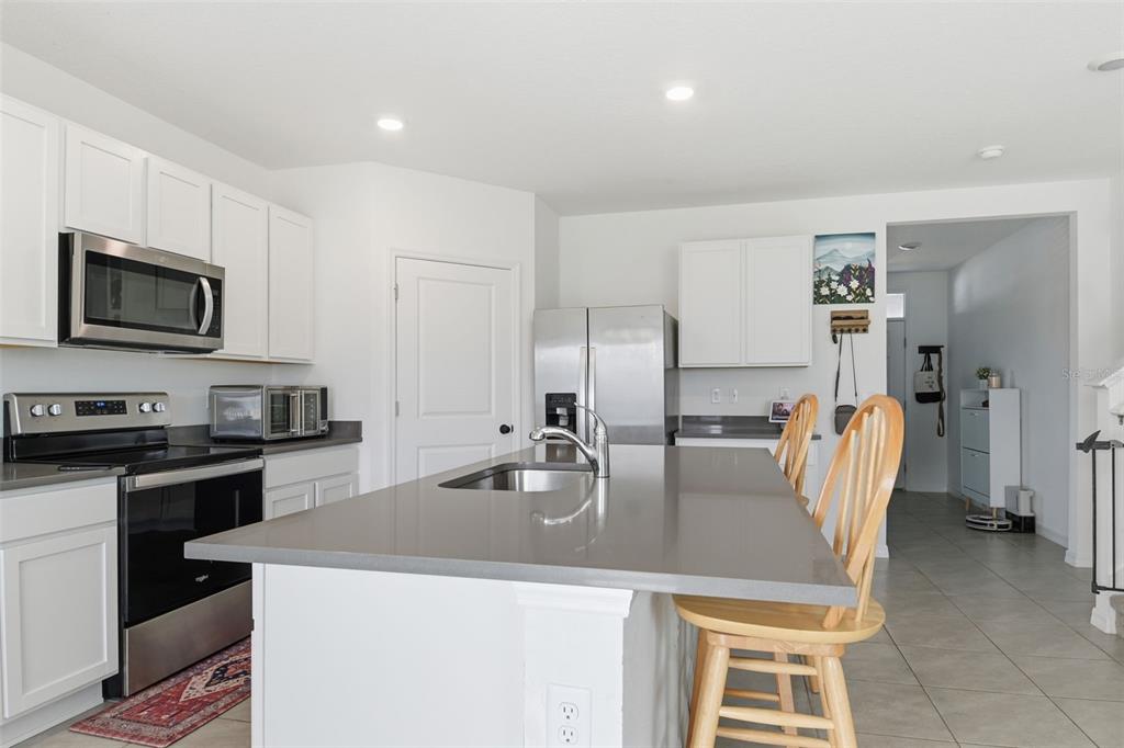 3844 Sunny Spring Street Plant City, FL 33565 - Photo 25 of 26 a kitchen with stainless steel appliances granite countertop a sink a stove top oven a counter space and cabinets