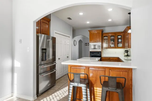 a kitchen with stainless steel appliances kitchen island a refrigerator and a stove