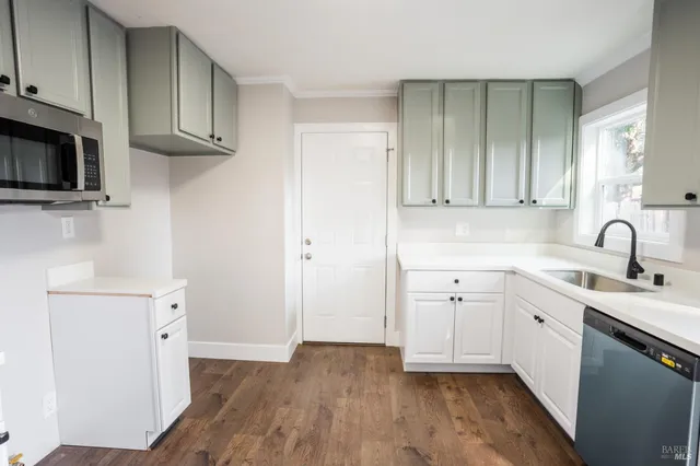 a kitchen with a sink a stove and cabinets