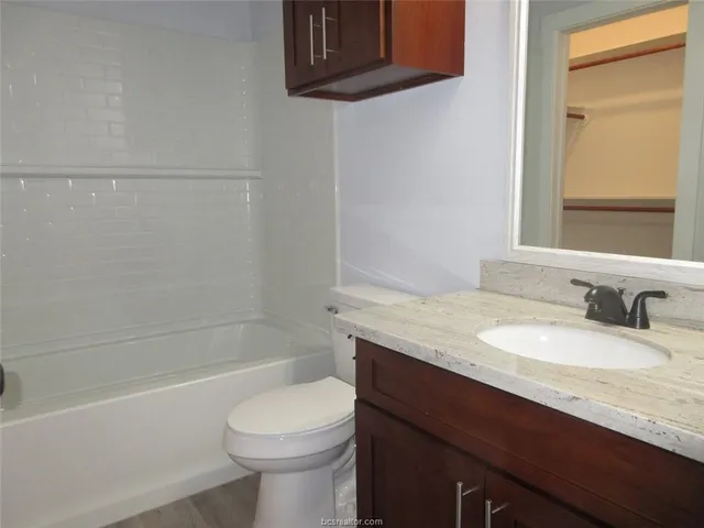 a bathroom with a granite countertop sink toilet and shower