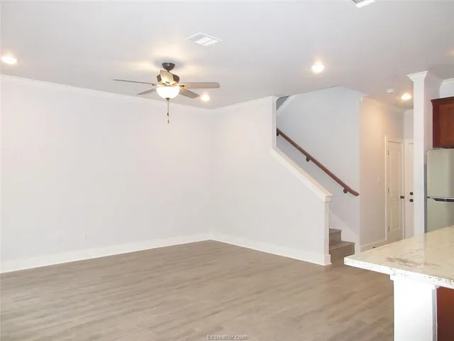 a view of a room with wooden floor and ceiling fan