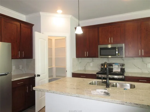 a kitchen with a sink a stove and a microwave oven