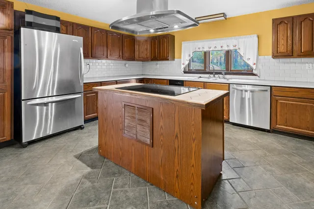 a kitchen with stainless steel appliances granite countertop a refrigerator a sink a stove and a microwave oven