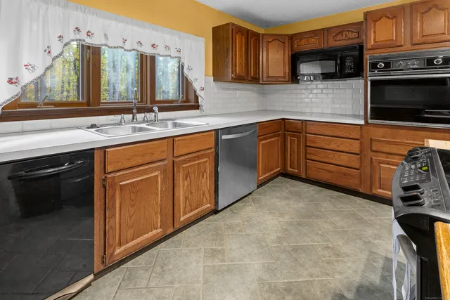 a kitchen with stainless steel appliances granite countertop a sink and a stove