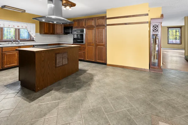 a kitchen with stainless steel appliances granite countertop a stove a sink and a refrigerator