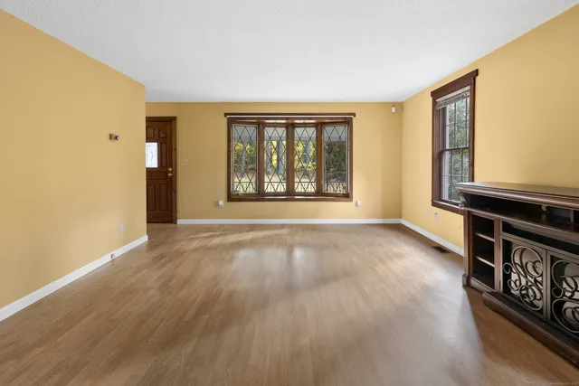 wooden floor in an empty room with a window