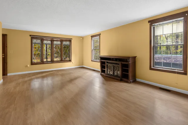 a view of an empty room with window and fireplace