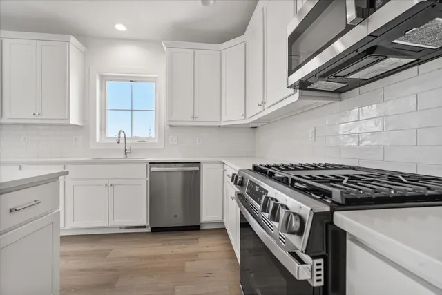 a kitchen with white cabinets and appliances