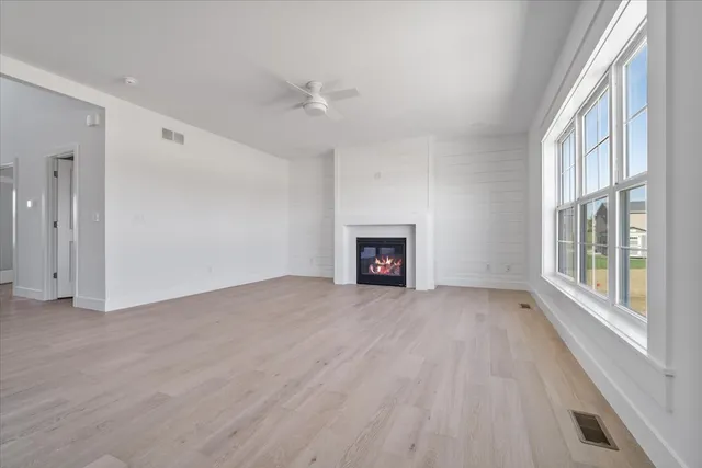 a view of an empty room with a window and fireplace