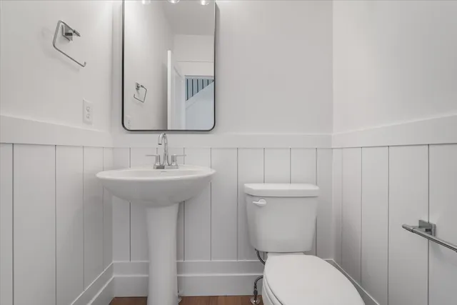 a bathroom with a toilet a sink and mirror