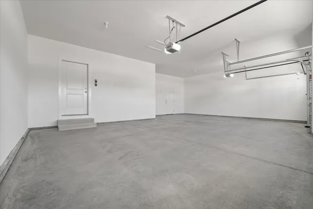 an empty room with ceiling fan and windows