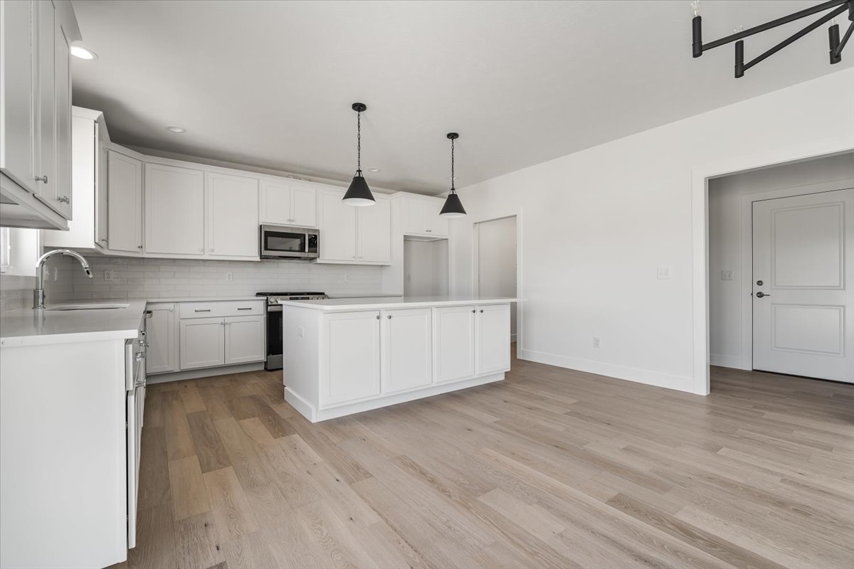 24 Stonehouse Court Bloomington, IL 61705 - Photo 9 of 45 a kitchen with kitchen island white cabinets and wooden floor