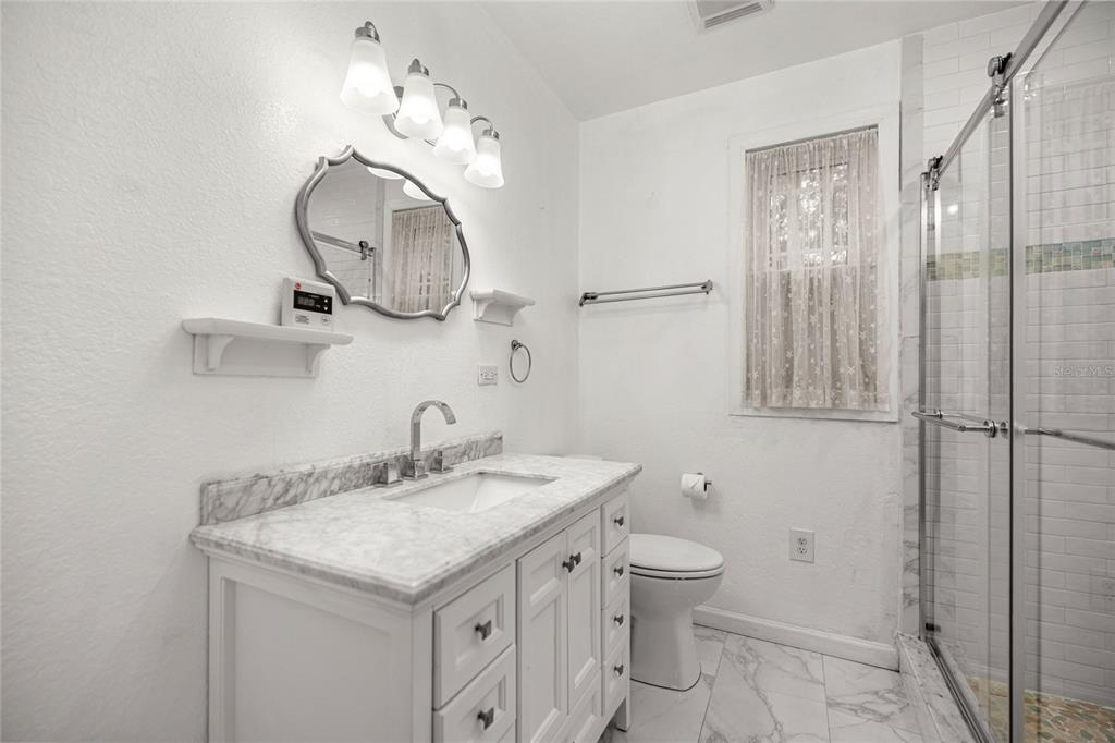 1226 Southeast 9th Avenue Ocala, FL 34471 - Photo 28 of 49 a bathroom with a granite countertop sink a toilet and a mirror